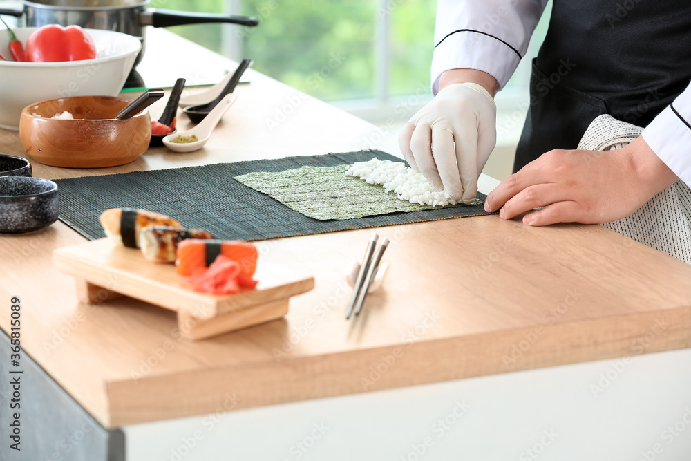 Handsome Asian chef cooking in kitchen, closeup