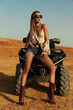 beautiful sexy woman with dark hair in casual clothes and accessories posing in desert with safari car