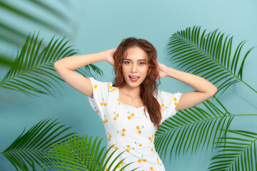 Wall Mural - Portrait of young and beautiful woman with perfect smooth skin in tropical leaves.