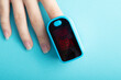 The pulse oximeter shows saturation on a finger on a blue background