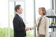 © cocorattanakorn - Successful businessman and businesswoman happy and shake hands after meeting for partnership in modern office
