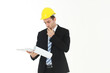 © cocorattanakorn - Handsome and smart engineer in black suit Wearing a yellow safety engineer hat with hand holding Construction drawing papers and serious in work isolated on yellow background. Copy Space