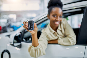 Wall Mural - close-up photo of black female hands holding car keys, attractive happy woman buy white automobile, smile at camera