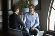© fizkes - Smiling caucasian businessman shake hand closing deal agreement with male business partners at office briefing, happy man colleagues handshake get acquainted greeting at meeting, partnership concept