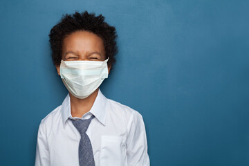 Black child boy in medical protective face mask laughing, portrait