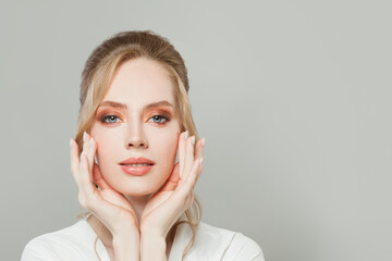 Wall Mural - Pretty young woman face with clear healthy skin, makeup and manicured nails on hands close up portrait