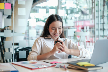 Wall Mural - Charming asian businesswoman sitting working on laptop in office.