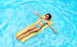 © Prostock-studio - Top view of attractive black girl floating on air mattress in blue water of outdoor pool