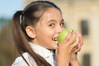 School girl bite green apple close up, healthy food concept