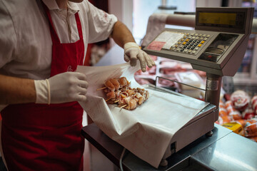 the butcher measures the meat on an electric scale