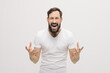 © Yuliya - Young handsome man wearing casual white t-shirt over white isolated background crazy and mad shouting and yelling with aggressive expression