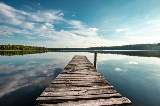 wooden pier on the background of a beautiful lake summer dawn landscape. copy space.