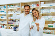 © hedgehog94 - Portrait of happy male and female pharmacists at modern pharmacy.