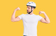 © Krakenimages.com - Young handsome man wearing bike helmet showing arms muscles smiling proud. fitness concept.