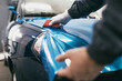 © hedgehog94 - Car wrapping specialist putting vinyl foil or film on car. Selective focus.