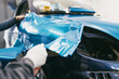© hedgehog94 - Car wrapping specialist putting vinyl foil or film on car. Selective focus.