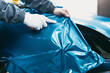 © hedgehog94 - Car wrapping specialist putting vinyl foil or film on car. Selective focus.