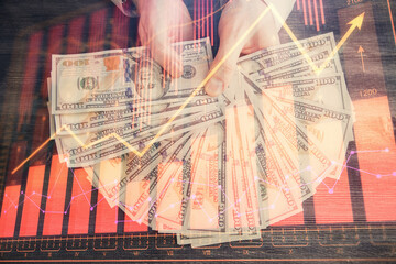 Multi exposure of financial graph drawing hologram and USA dollars bills and man hands. Analysis concept.