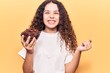 © Krakenimages.com - Beautiful kid girl with curly hair holding chocolate cereals screaming proud, celebrating victory and success very excited with raised arm