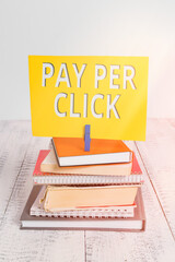 Conceptual hand writing showing Pay Per Click. Concept meaning internet marketing in which payment is based on clickthrough pile stacked books notebook pin color reminder white wooden