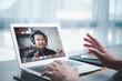 © Looker_Studio - Asian business man making FaceTime video calling using online meeting via laptop computer at home office. concept of work from home teleconference and video conference.