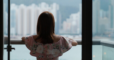 Wall Mural - Woman go out balcony and look around the city