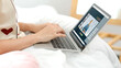 © weedezign - Asian female student video conference with teacher and friends using e-learing app on laptop computer at home.woman lying down on carpet.new normal learning online lifestyle