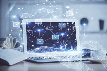 Desktop computer background in office and flying envelops hologram drawing. Double exposure. Electronic mail concept.