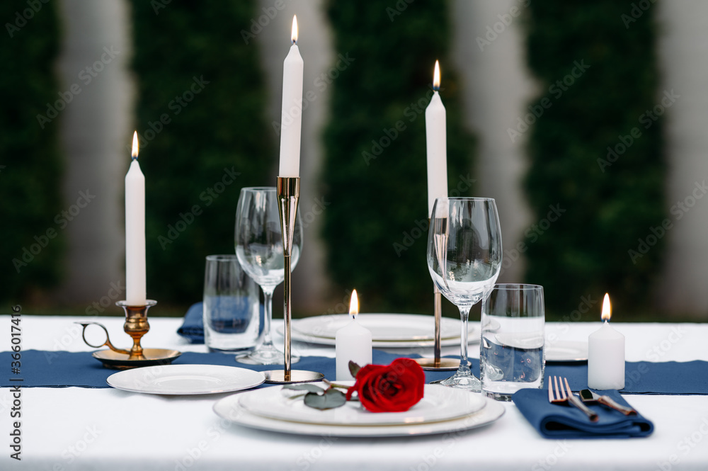 Table setting, wineglasses, candles and flower - obrazy, fototapety, plakaty 