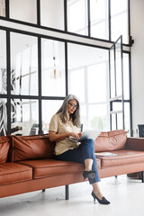 Canvas Print - Beautiful mature positive woman using laptop computer.