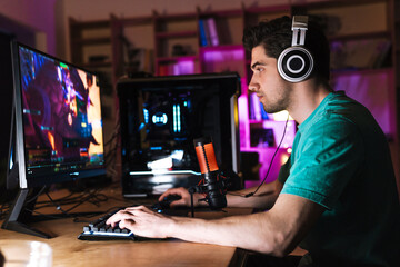 Wall Mural - Image of caucasian focused man playing video game on computer