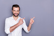 © deagreez - Portrait of positive cheerful man marketer ceo point index finger copyspace recommend suggest select advert promo wear white shirt isolated over gray color background