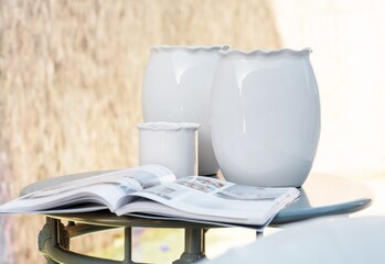 Sticker - Closeup shot of a magazine and white ceramic pots on a table