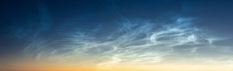 Wall Mural - noctilucent clouds. night glowing silvery clouds. wide panorama.