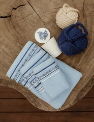 Canvas Print - Overhead shot of decorative towels, soap, and wool threads on a tree stump