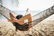 © Peera - Traveler asian woman relax in hammock on summer beach Thailand