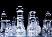 The King And The Queen, Transparent Pieces Of The Game Of Chess, Over A Glass Chessboard. Seen From One Of The Players' Perspective.
