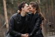 © Denys - young couple in black jackets hugging and posing in the forest.