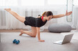 © Admiral - Sporty woman doing plank yoga exercise and watching online workout session on laptop, training in living room