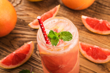 Wall Mural - A glass of ripe grapefruit with juice on wooden table close-up