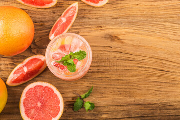 Wall Mural - A glass of ripe grapefruit with juice on wooden table close-up