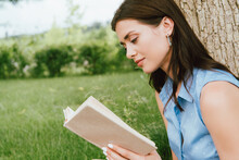 Beautiful Young Woman Reading Book Outside