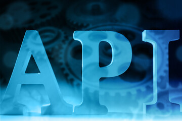 API logo. Inscription API next to the gears. Programming. Application programming interface. Concept - connection using API protocol. Website and application development. Data transfer between app