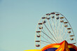 Retro toned picture of a Ferris wheel in an amusement park with cloudless sky, space for text.