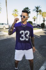 Wall Mural - Young European hip male in street style sporty outfit with sunglasses and tattoos on his hands