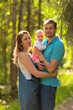 © Sk Elena - Mother, father and baby walking in the park. Summer time. Happy family spent time together outdoors. Man holds his daughter in the arms.