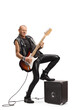 Full length shot of a rock star playing a guitar with his leg on an amplifier
