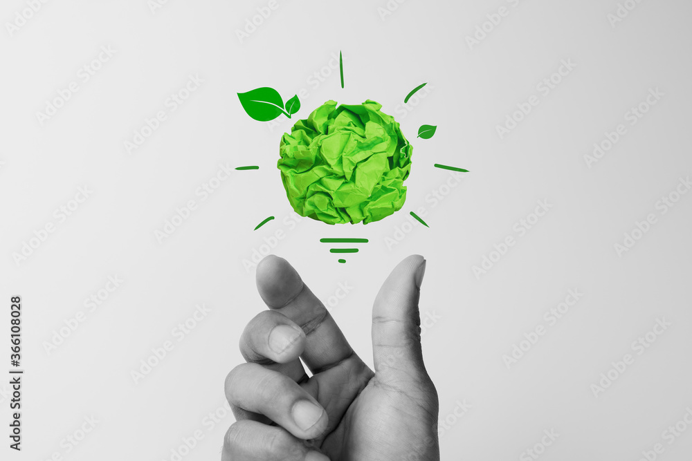 Corporate Social Responsibility (CSR), eco-friendly business concepts with businessman hand holding crumpled green paper light bulb - obrazy, fototapety, plakaty 
