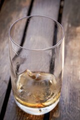 Poster - Vertical selective focus shot of an empty glass on wooden table