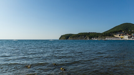 Wall Mural - Scenic sea landscape with blue water of Black Sea with rocky coast on the horizon. Olginka village, Tuapse, the Black Sea, Russia.